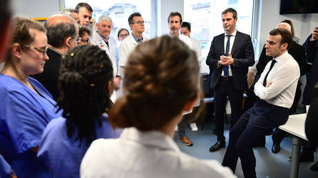 French President Emmanuel Macron visits a Paris hospital where a patient infected with COVID-19 has died. February 27, 2020.