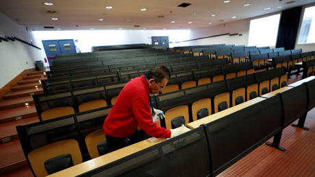 A man cleans an empty class room at the Bicocca University in Milan. © REUTERS/Guglielmo Mangiapane