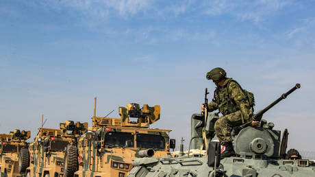 FILE PHOTO: Russian (front) and Turkish military vehicles drive on a joint patrol in Syria's north-eastern Hasakeh province on November 1, 2019.