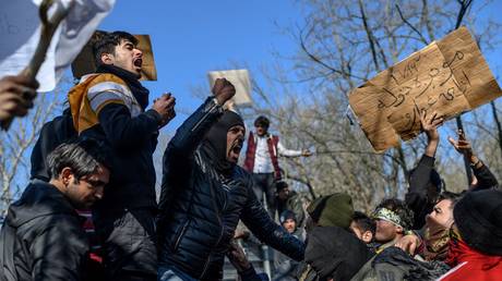 Migrants chant slogans as they demonstrate in the Turkey-Greece border buffer zone, near Pazarkule crossing gate in Edirne, Turkey, on March 6, 2020.