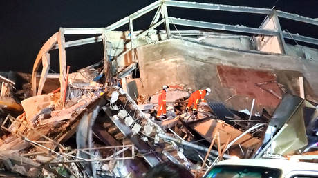 Rescue workers are seen on the site where a hotel being used for the novel coronavirus quarantine collapsed iin Quanzhou, China on March 7, 2020.