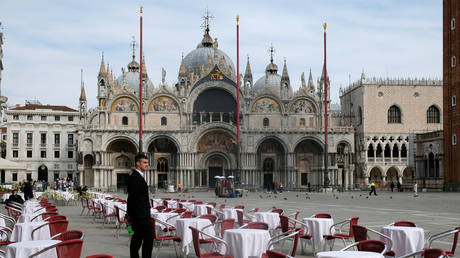A waiter stands by empty tables outside a restaurant at St Mark's Square after the Italian government imposed a virtual lockdown on the north of Italy including Venice to try to contain a coronavirus outbreak, in Venice, Italy, March 9, 2020. © REUTERS/Manuel Silvestri