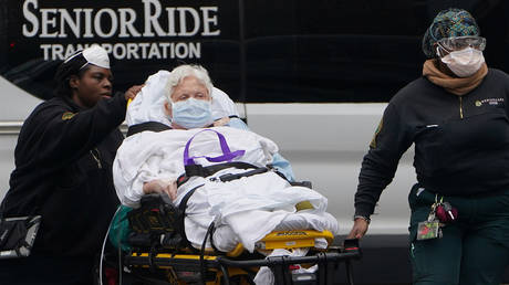 Paramedics move a patient into a hospital, in New York City, New York, US, March 25, 2020.