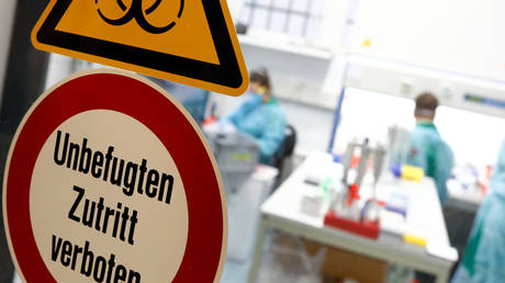 Employees in protective clothing perform tests for the corona virus at a laboratory in Berlin, Germany. © Reuters / Axel Schmidt