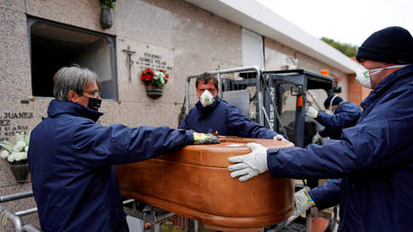 Mortuary employees carrying the coffin of a person who died from Covid-19 in Madrid, Spain, on Friday. © REUTERS/Juan Medina