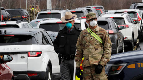 US Military personnel and police stand amid a line of cars of people arriving for testing at a drive-thru coronavirus disease testing center in Staten Island New York. © Reuters / Mike Segar