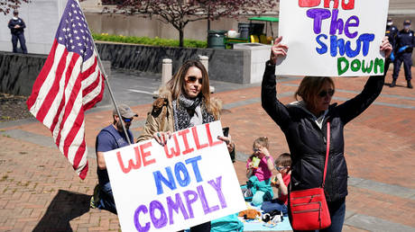 FILE PHOTO: Protesters hold signs in opposition to Virginia's stay-at-home order, part of a growing number of residents across several states demanding an end to lockdown measures.