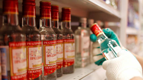 An employee places bottles of vodka in a supermarket amid the coronavirus pandemic in Moscow. © Reuters / Maxim Shemetov