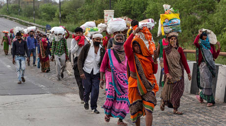 FILE PHOTO: People walk along a road to return to their villages. New Delhi, India. March 2020 © REUTERS / Danish Siddiqui