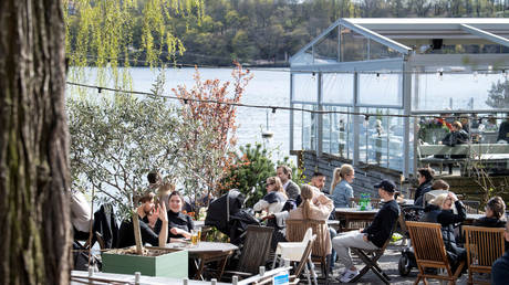 People enjoy the spring weather at an outdoor restaurant in Stockholm, Sweden April 26, 2020.