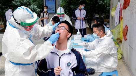 Workers in protective suits collect swabs from senior high school students at Hubei Wuchang Experimental High School before the students in Wuhan, April 30, 2020. © Reuters
